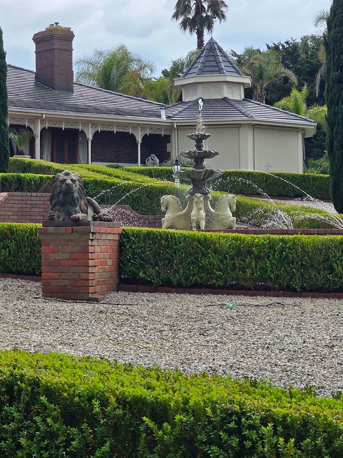 Tiered fountain with winged horses and a stone lion
